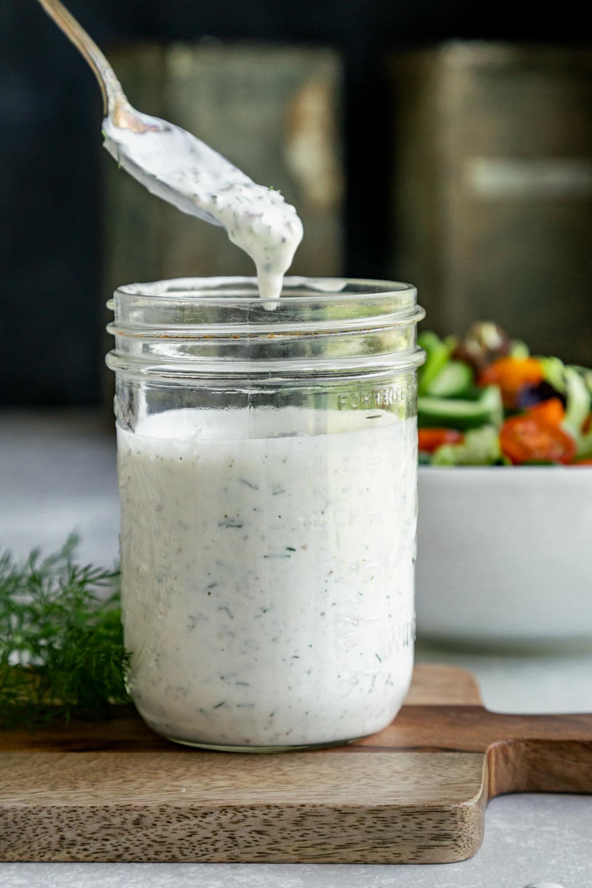 a spoon dipping into a jar of ranch