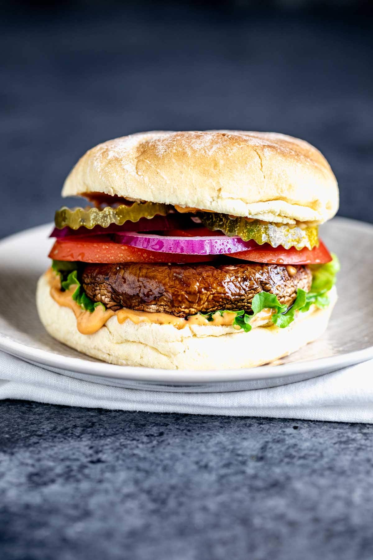 a single portobello mushroom sandwich loaded with toppings and burger sauce