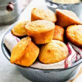 muffins in a metal bowl with a kitchen cloth