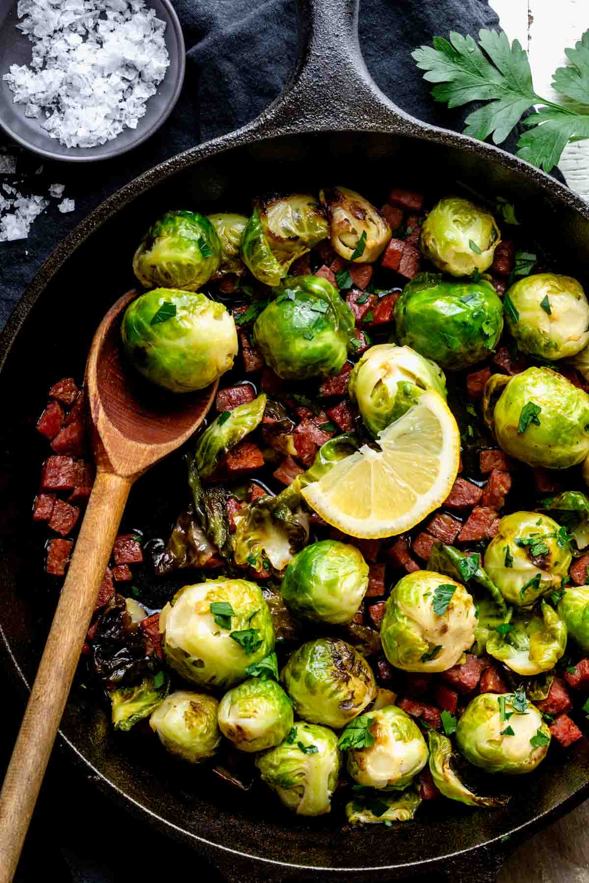 black skillet with Brussels and wooden spoon