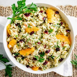 overhead photo of brown rice with cranberries and oranges in a bowl