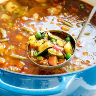 Garden Vegetable Soup in a ladle over a pot of soup