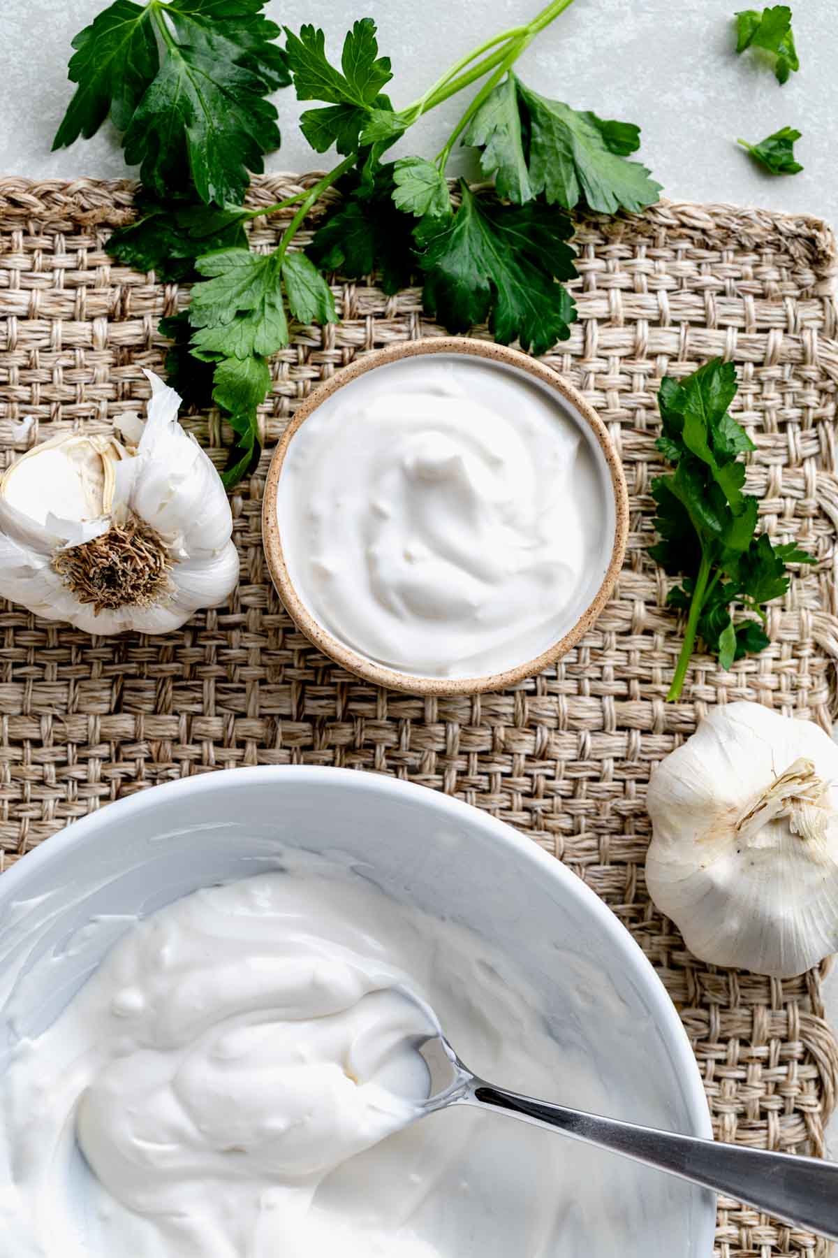 Greek yogurt aioli in a small serving bowl and the white mixing bowl