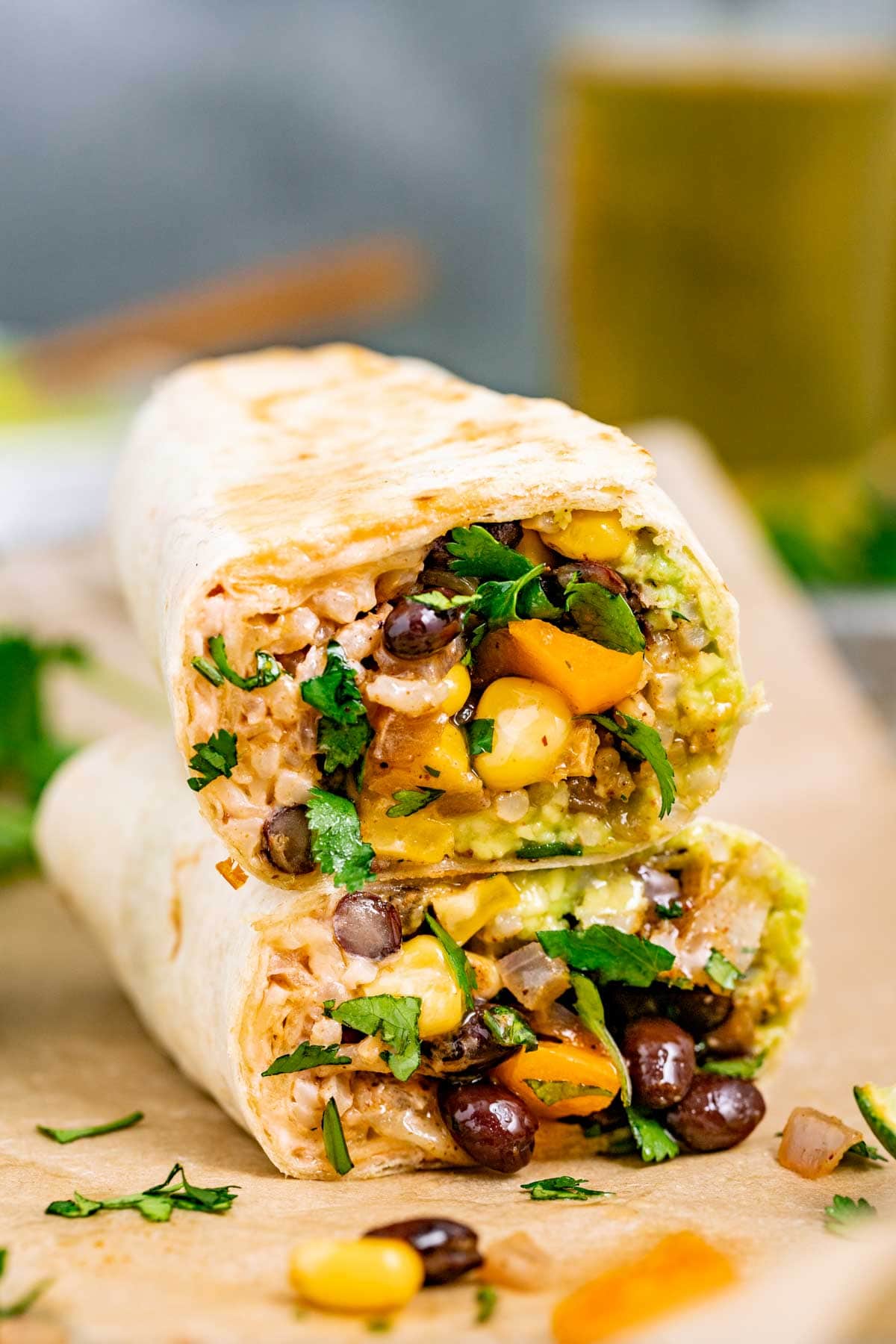 two veggie burritos stacked on top of each other with the burrito filling showing towards the camera