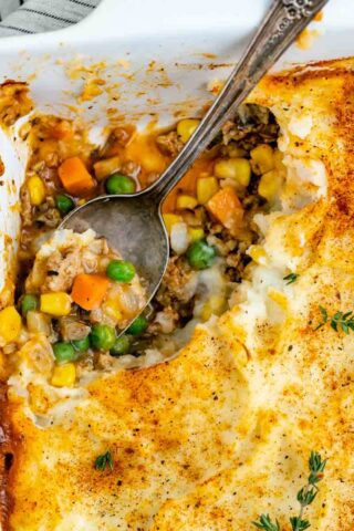 ground turkey shepherd's pie with a spoonful scooped out of the corner of the casserole dish with the spoon in the empty spot