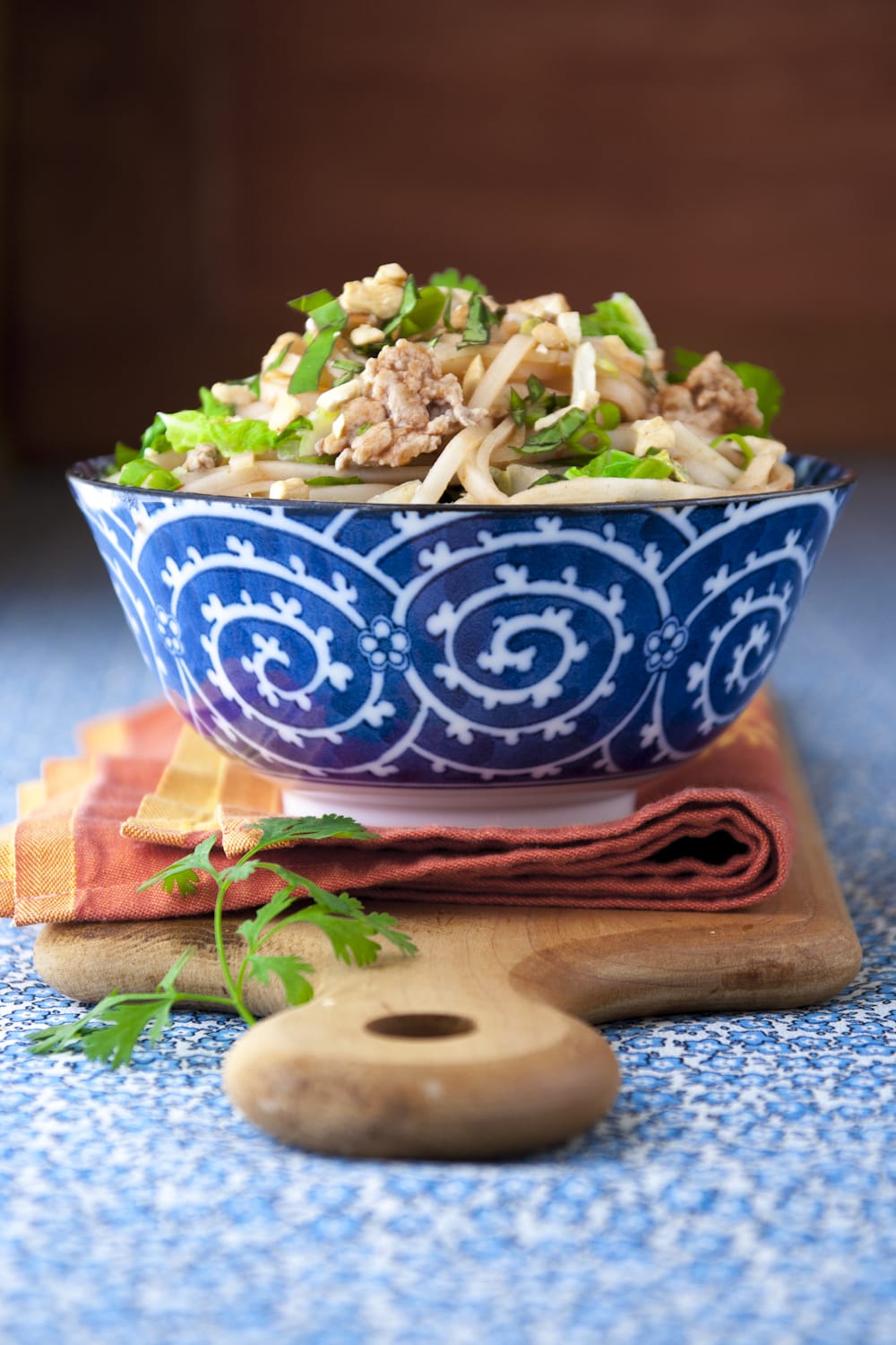 blue and white bowl with turkey pad thai in it