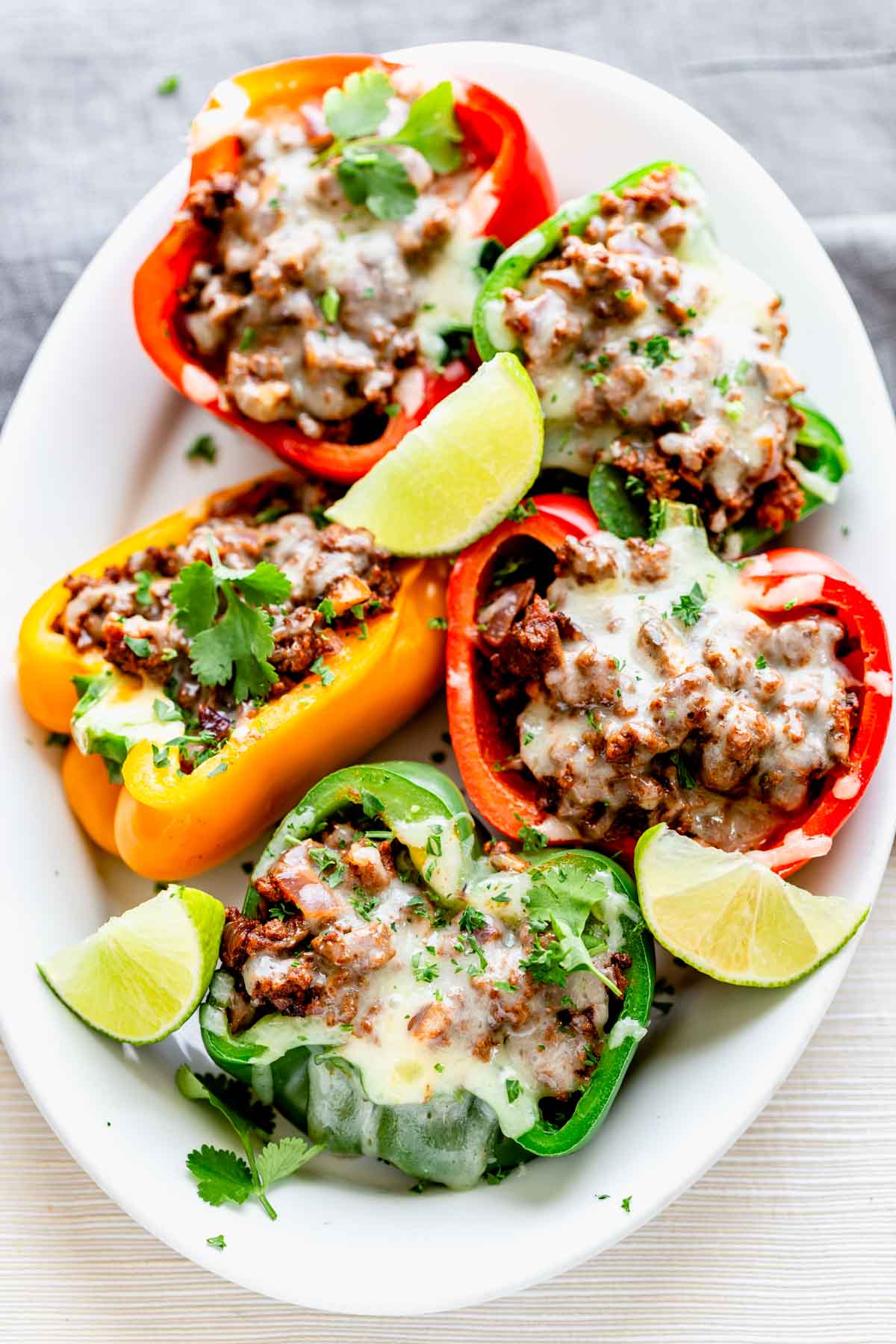 overhead shot of low-carb stuffed Mexican peppers on white plate