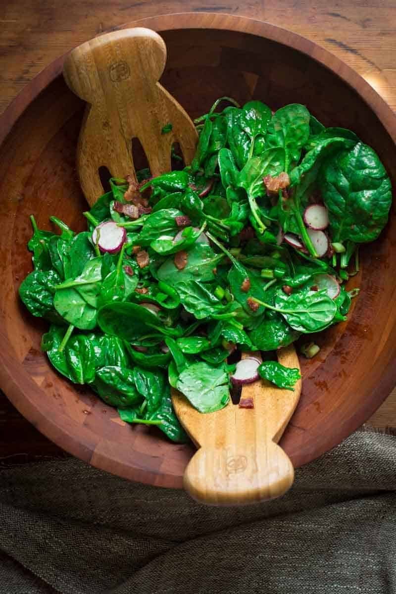 Spinach and Scallion Salad with hot honey dressing in a salad bowl 