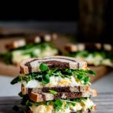 egg salad and watercress sandwich cut in half and stacked on top of each other