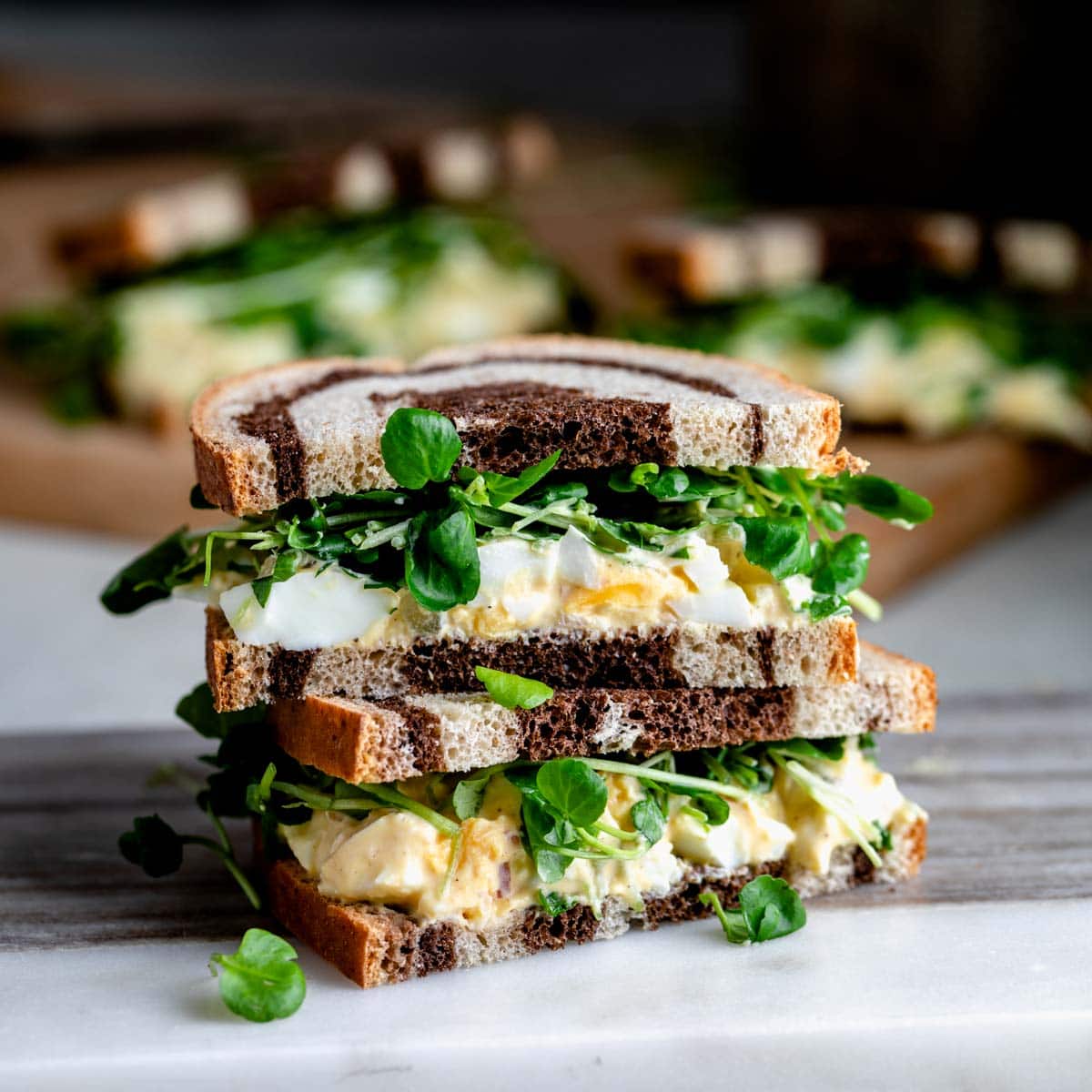 watercress sandwich cut in half and stacked on top of each other with the inside of the sandwich facing the camera