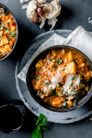 Ribollita soup in two black bowls with parm