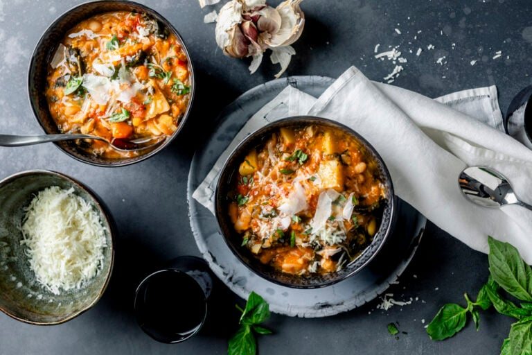 Ribollita soup in two black bowls with parm